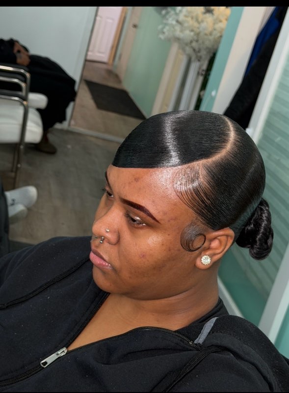 Sleek side part into a low bun
