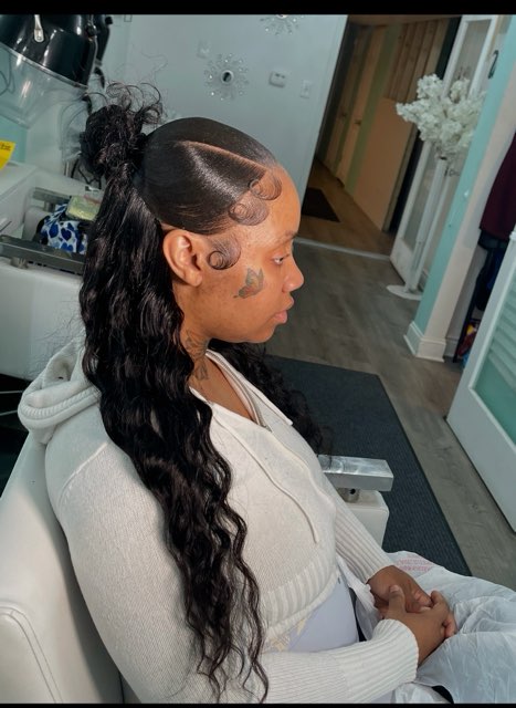 High ponytail with long waves and a shaved side design